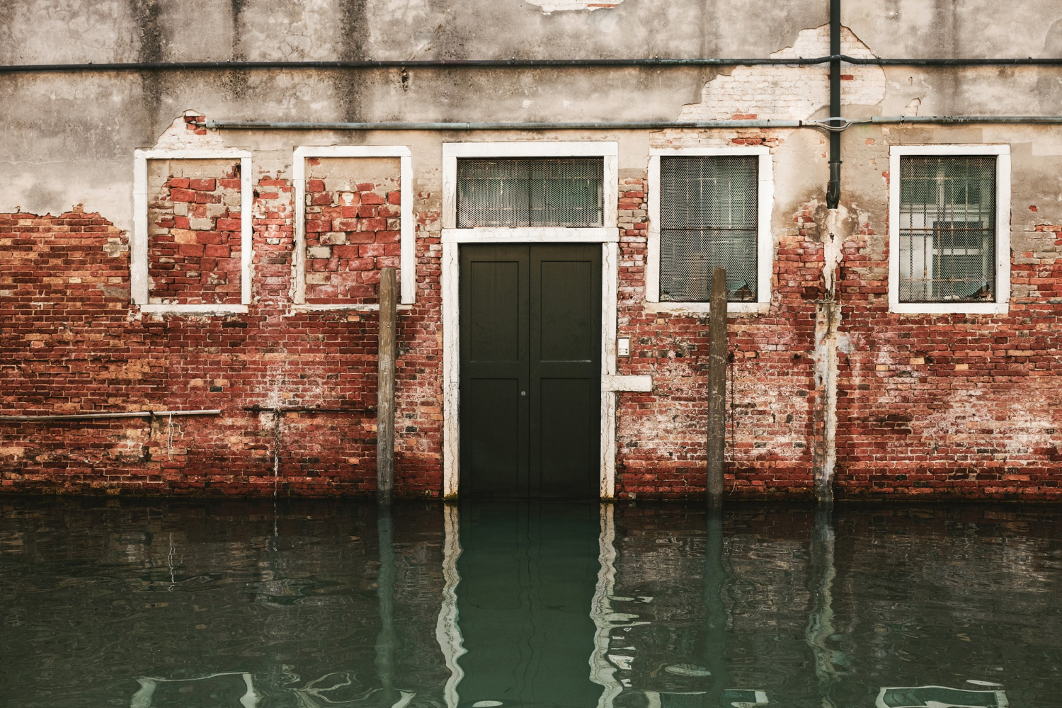 Floodwater surrounding the entrance of a brick commercial building