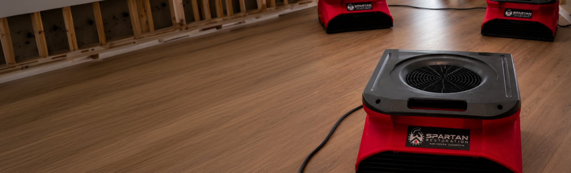 Spartan Restoration air movers drying a water-damaged hardwood floor